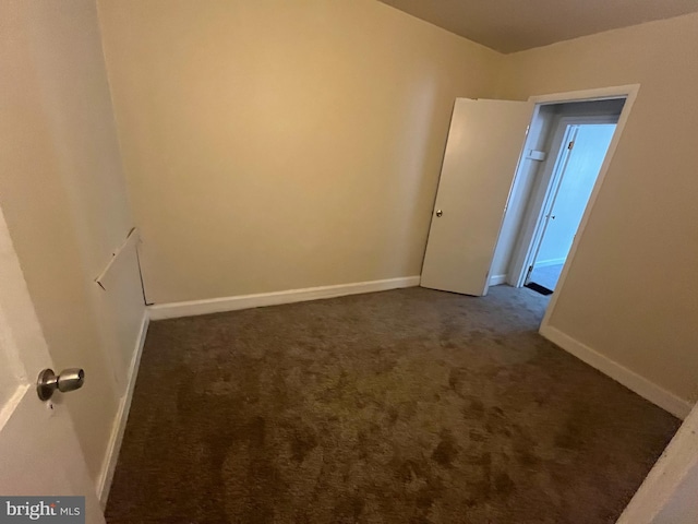 empty room featuring dark carpet