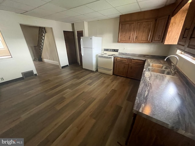 kitchen with sink, a drop ceiling, white appliances, and dark hardwood / wood-style flooring