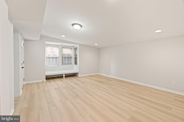 unfurnished room with light wood-type flooring and lofted ceiling