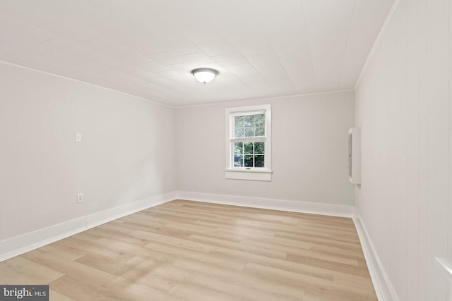 unfurnished room featuring light wood-type flooring and ornamental molding