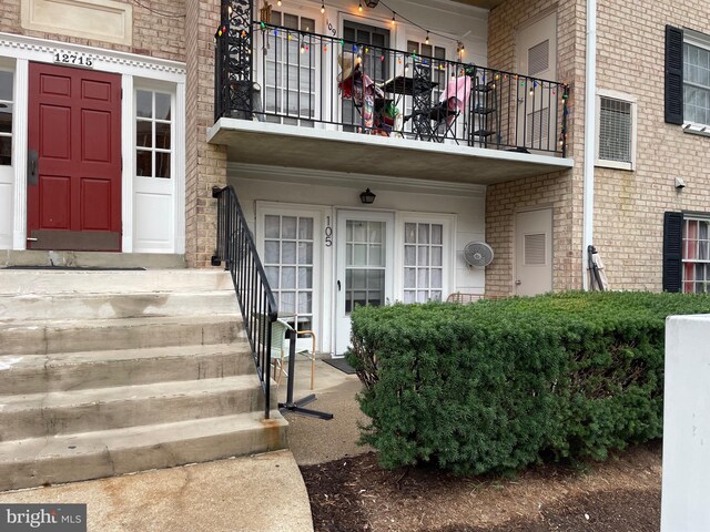 view of front facade with a balcony and french doors