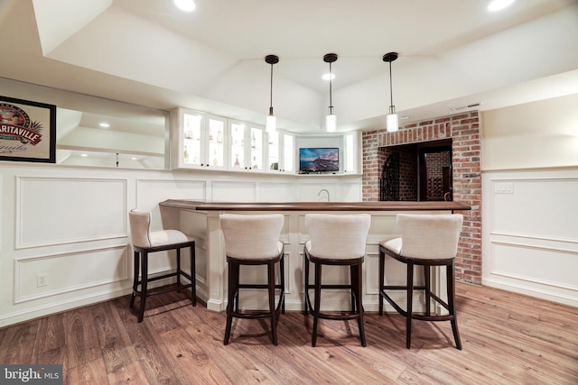 bar with pendant lighting, sink, light wood-type flooring, and white cabinets