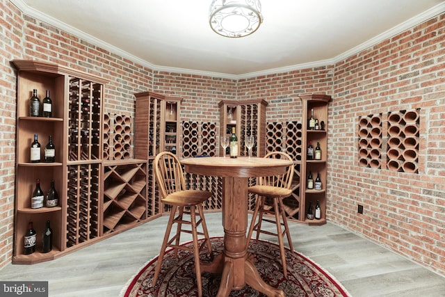 wine cellar featuring crown molding, wood-type flooring, and brick wall