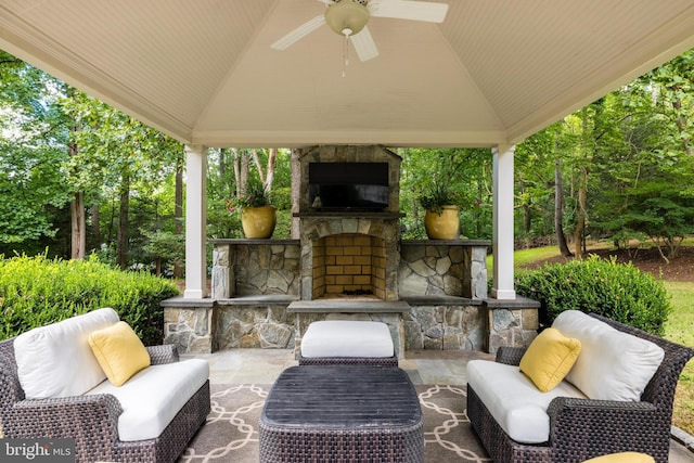 view of patio / terrace with a gazebo, an outdoor living space with a fireplace, and ceiling fan