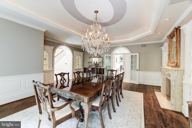 dining area featuring french doors, an inviting chandelier, a raised ceiling, and dark hardwood / wood-style flooring