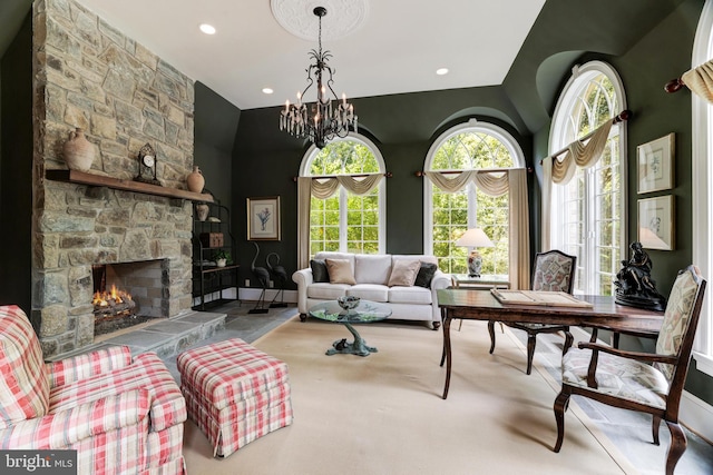 living room featuring a notable chandelier, vaulted ceiling, and a fireplace