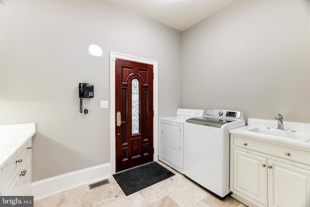 clothes washing area featuring cabinets, washer and dryer, and sink