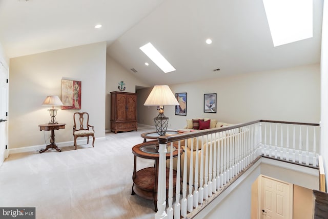 interior space with vaulted ceiling with skylight and light carpet