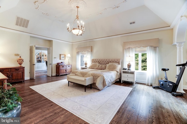 bedroom with a chandelier, a raised ceiling, dark wood-type flooring, and vaulted ceiling