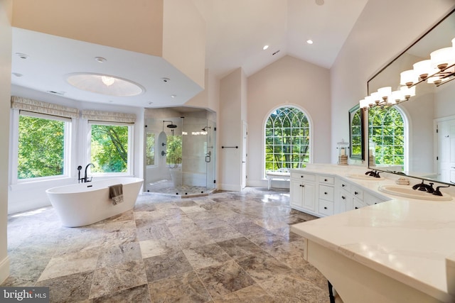 bathroom with vanity, high vaulted ceiling, plus walk in shower, and a wealth of natural light