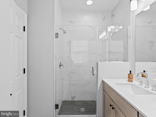 bathroom with a shower with door and vanity