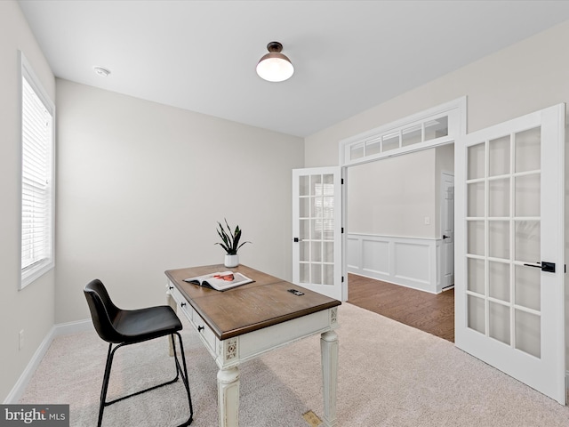 office area with a healthy amount of sunlight, dark hardwood / wood-style flooring, and french doors