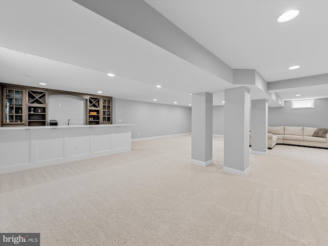 basement with light colored carpet, baseboards, indoor bar, and recessed lighting