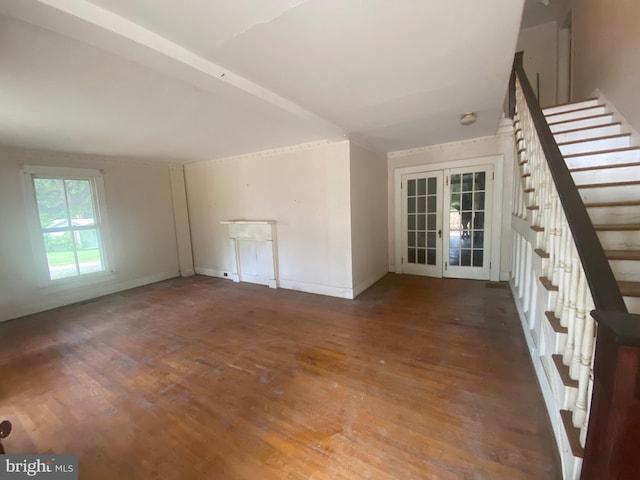 unfurnished room with wood finished floors, french doors, baseboards, and stairs