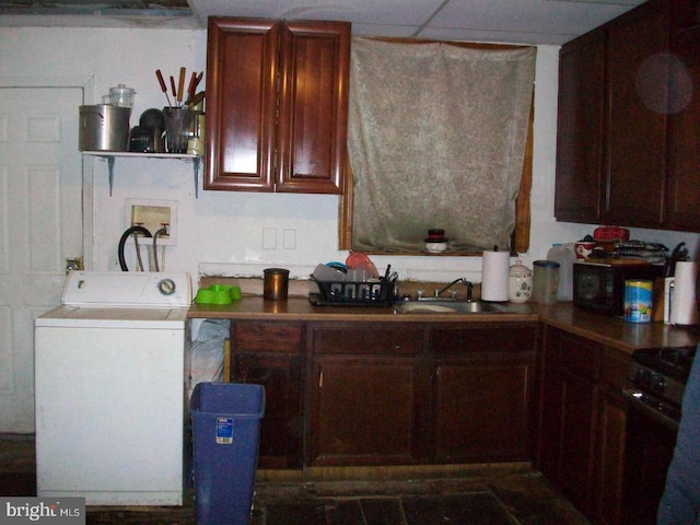 kitchen with sink, range, and washer / clothes dryer