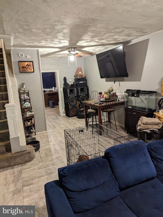 tiled living room featuring ceiling fan and a textured ceiling