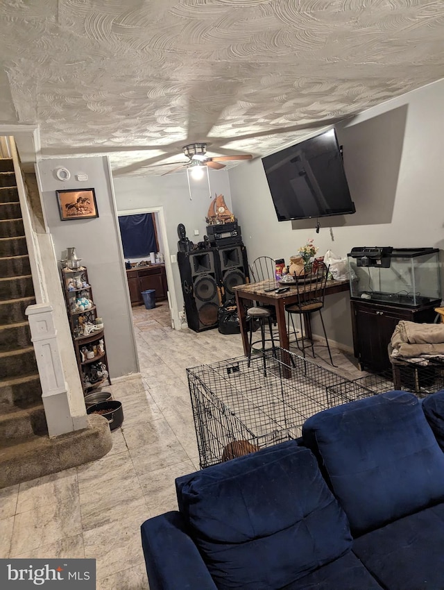 tiled living room featuring a textured ceiling and ceiling fan