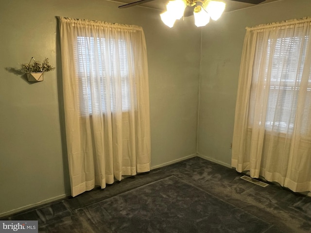 carpeted empty room with ceiling fan and plenty of natural light