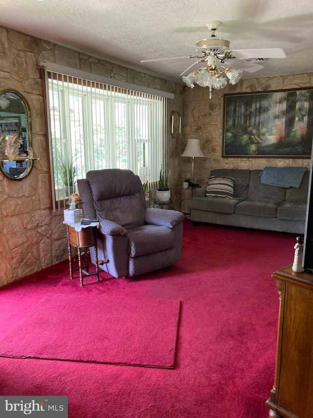 living room with ceiling fan, carpet, and a textured ceiling