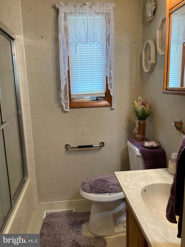 full bathroom featuring tile patterned flooring, vanity, toilet, and enclosed tub / shower combo