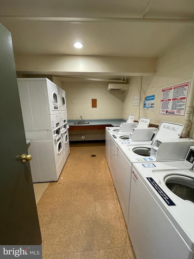 laundry room featuring separate washer and dryer, sink, and stacked washer and clothes dryer