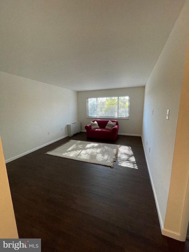 unfurnished living room with dark wood-type flooring