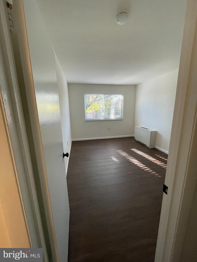 unfurnished room featuring dark wood-type flooring