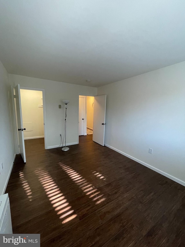 unfurnished room featuring dark wood-type flooring