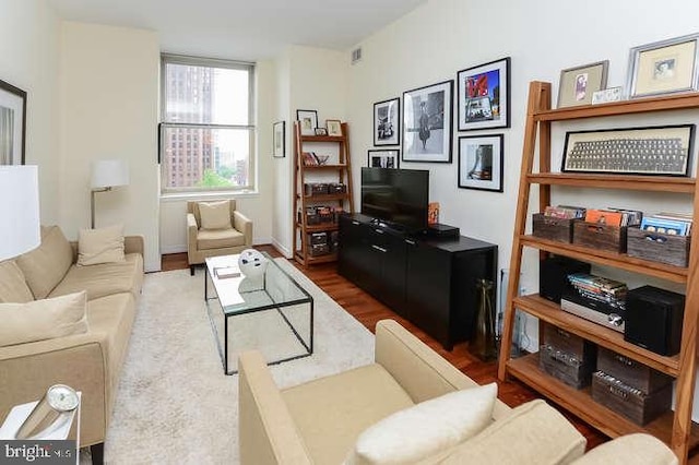 living area with visible vents and wood finished floors