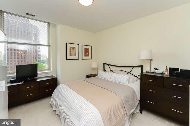 bedroom with visible vents and light colored carpet