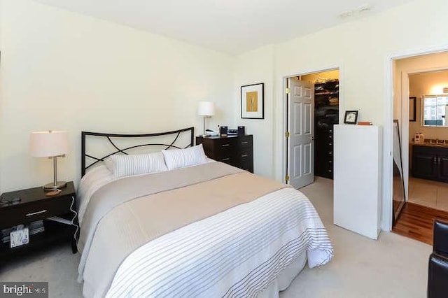 bedroom featuring a walk in closet, a closet, and ensuite bathroom