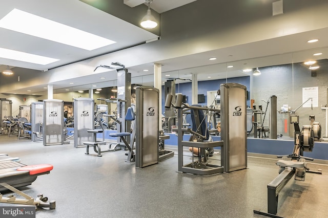 exercise room featuring recessed lighting, baseboards, and a skylight