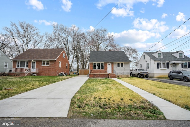 view of front of home with a front yard, concrete driveway, and brick siding