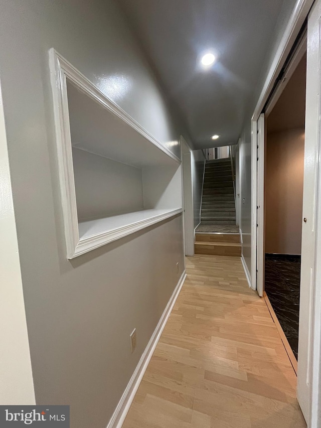 corridor with recessed lighting, baseboards, stairway, and light wood finished floors