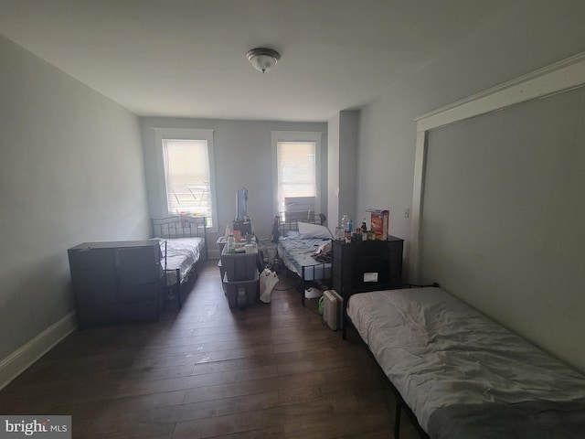 bedroom with dark wood finished floors and baseboards