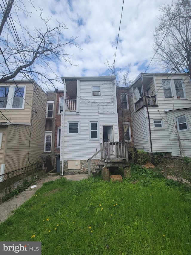 back of house with a yard and a balcony