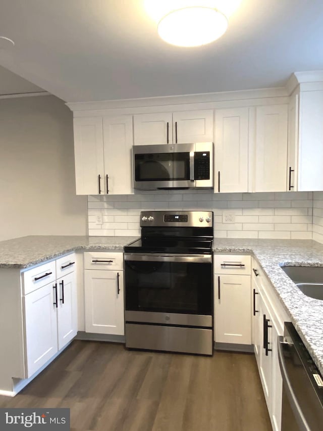 kitchen featuring dark wood-style floors, stainless steel appliances, light stone counters, and white cabinetry