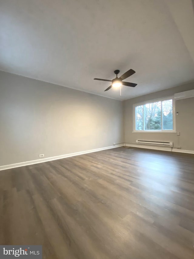 spare room with ceiling fan, dark wood-type flooring, and baseboard heating