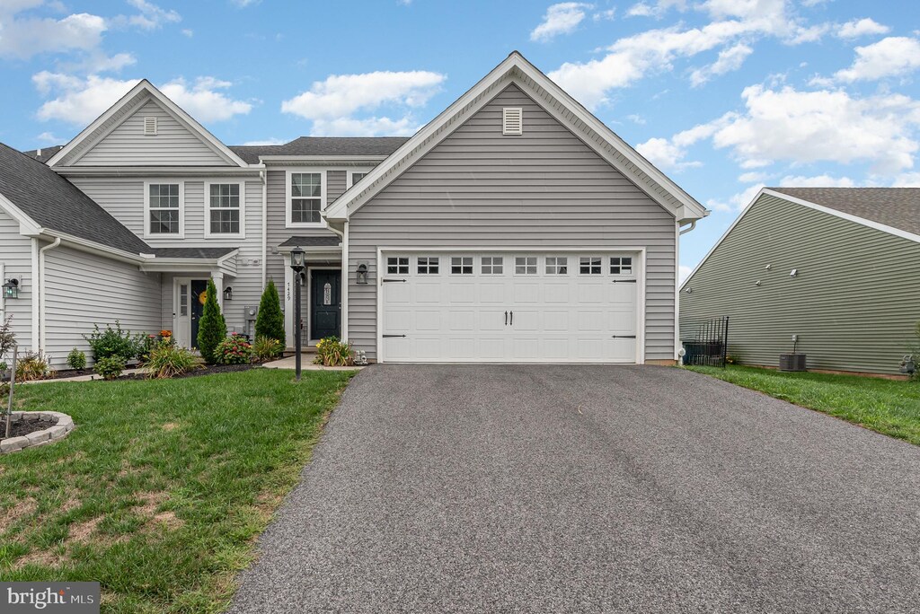 front facade featuring a garage and a yard