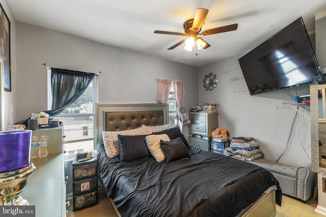 bedroom with light hardwood / wood-style floors, ceiling fan, and multiple windows