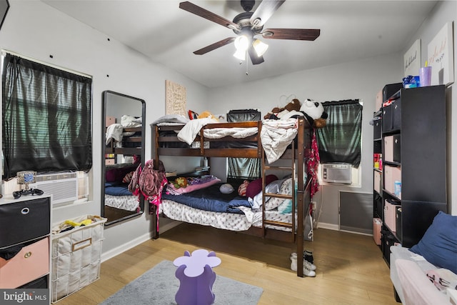 bedroom featuring light wood-type flooring, ceiling fan, and cooling unit