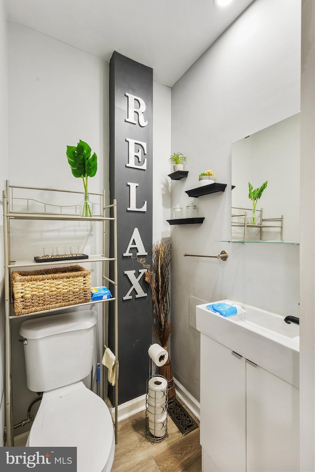 bathroom featuring hardwood / wood-style flooring, toilet, and vanity