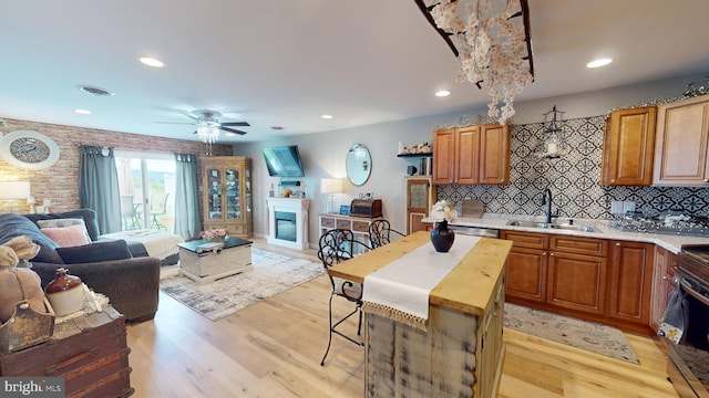 kitchen featuring a center island, open floor plan, light countertops, and a sink