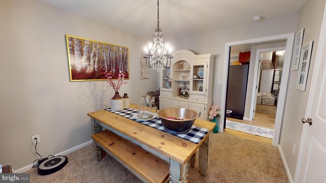 carpeted dining space with a notable chandelier