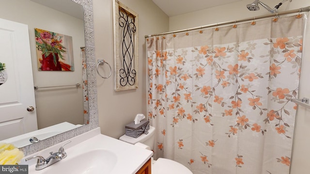 bathroom featuring curtained shower, vanity, and toilet