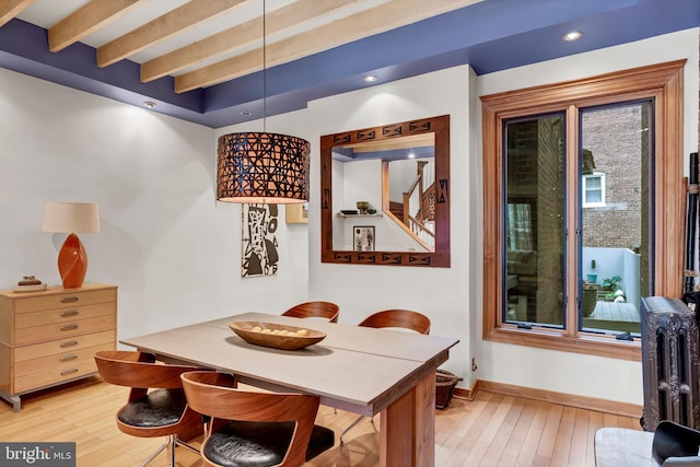 dining room featuring light wood-type flooring and beam ceiling