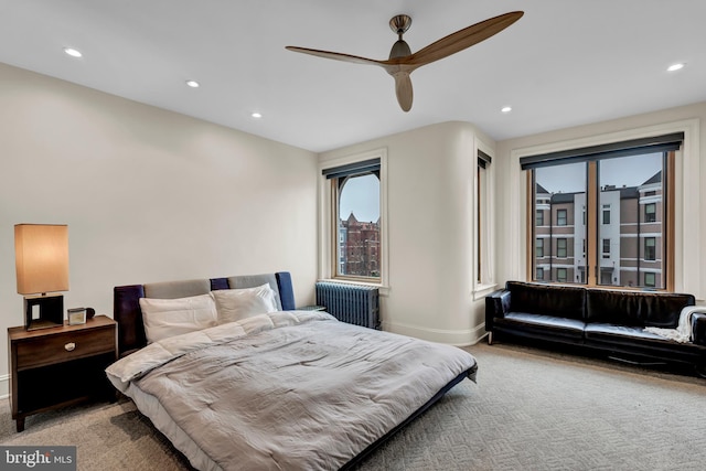 bedroom with carpet flooring, ceiling fan, and radiator