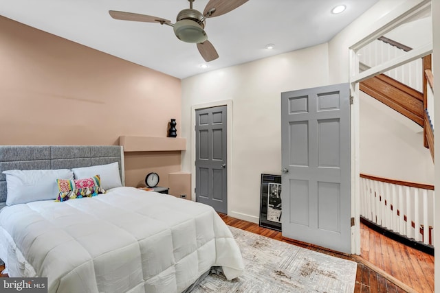 bedroom featuring wood-type flooring, wine cooler, and ceiling fan