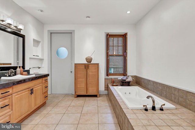 bathroom with vanity, tiled tub, and tile patterned floors