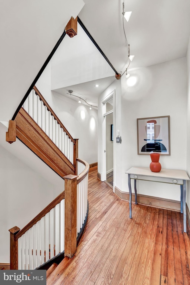 hall featuring track lighting and wood-type flooring